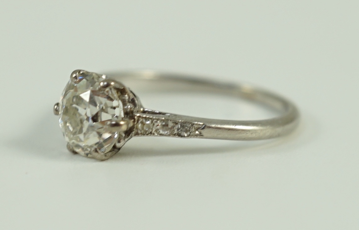 A platinum and single stone diamond ring, with diamond chip set shoulders